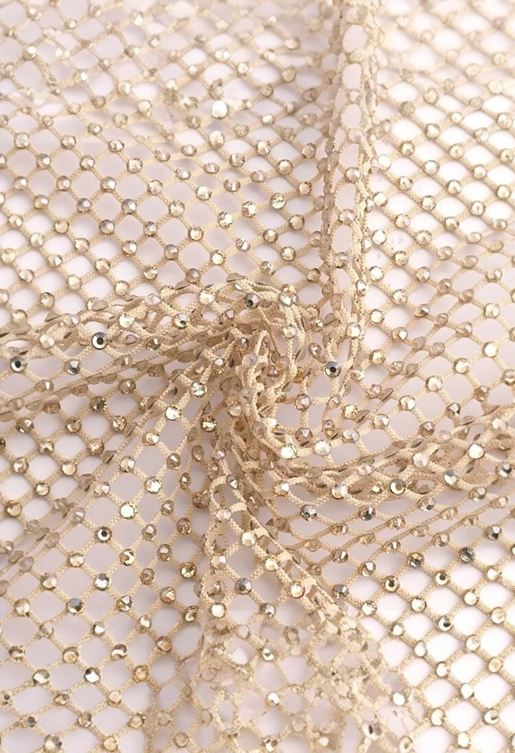 SlaySwimwear beige fishnet mini skirt with all-over rhinestone embellishments and clasp closure.