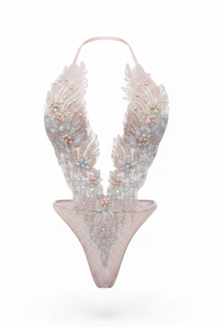 SlaySwimwear blush pink sheer mesh bodysuit with feather embroidery, beadwork, and crystal accents. Plunging neckline, high-cut leg.