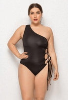 SlaySwimwear black one-shoulder swimsuit with lace-up sides. Model is wearing a size XL.