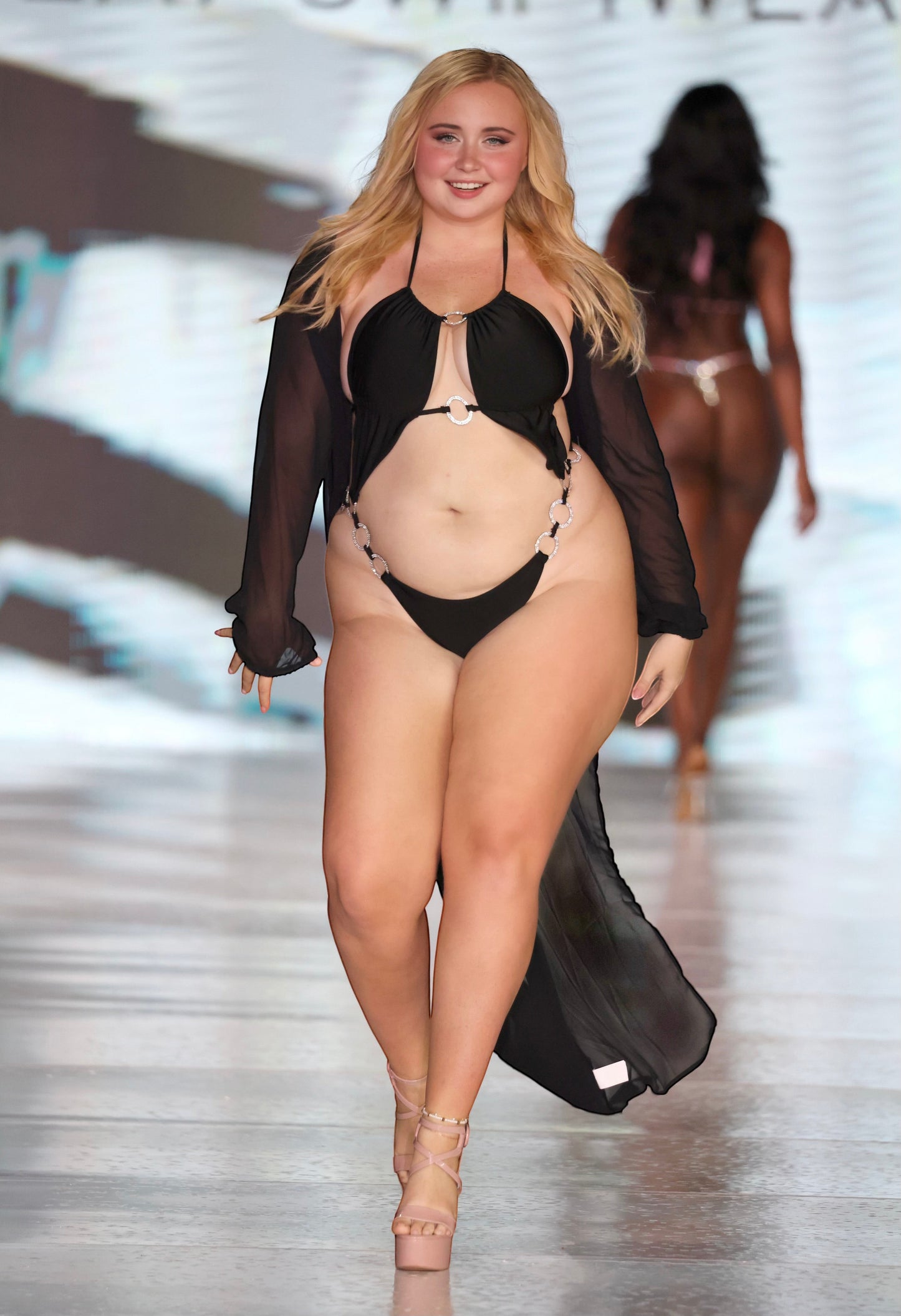 SlaySwimwear black monokini with O-ring cutouts and rhinestone accents, adjustable halter top, high-cut leg, and sheer black cover-up.