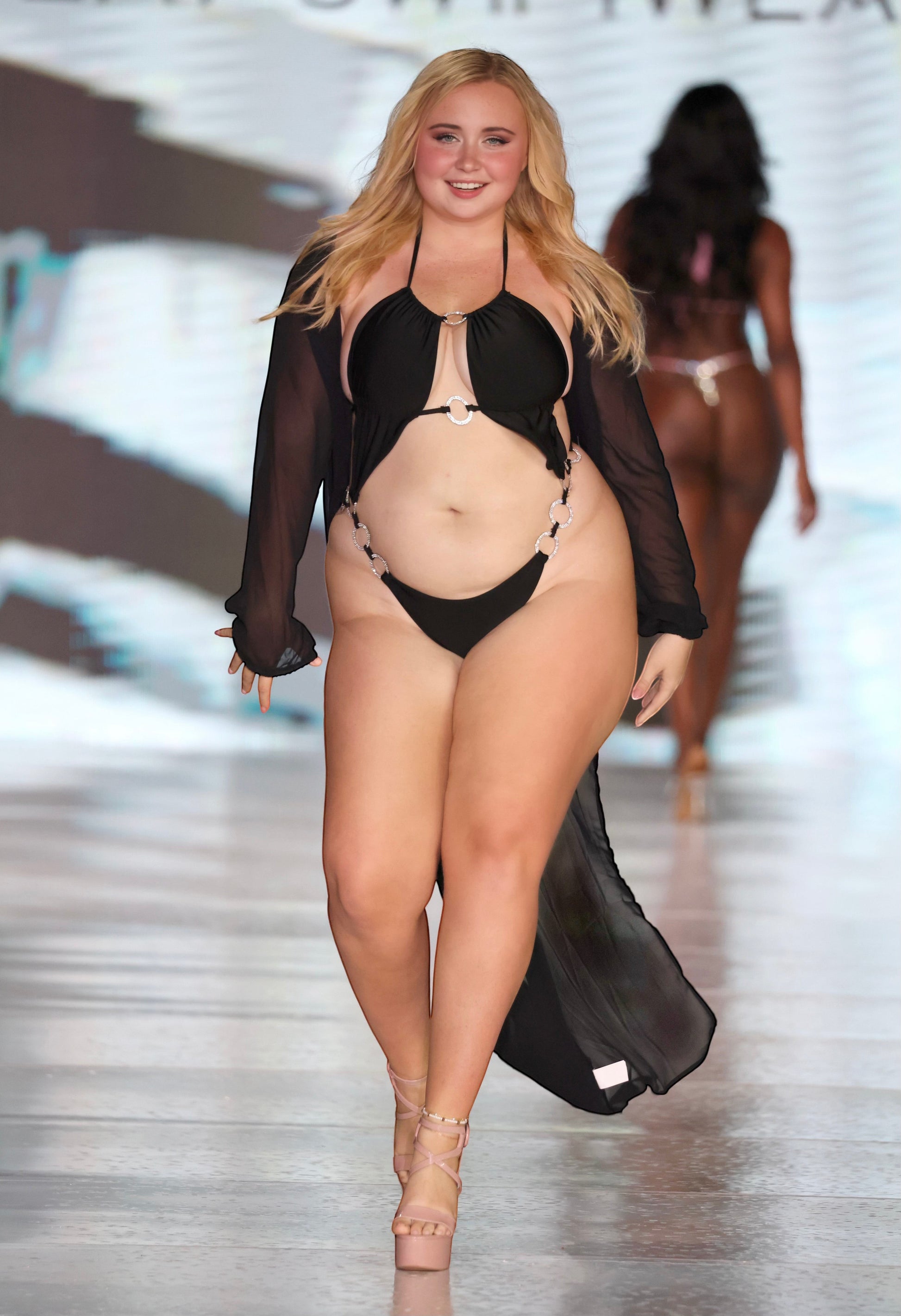SlaySwimwear black monokini with O-ring cutouts and rhinestone accents, adjustable halter top, high-cut leg, and sheer black cover-up.