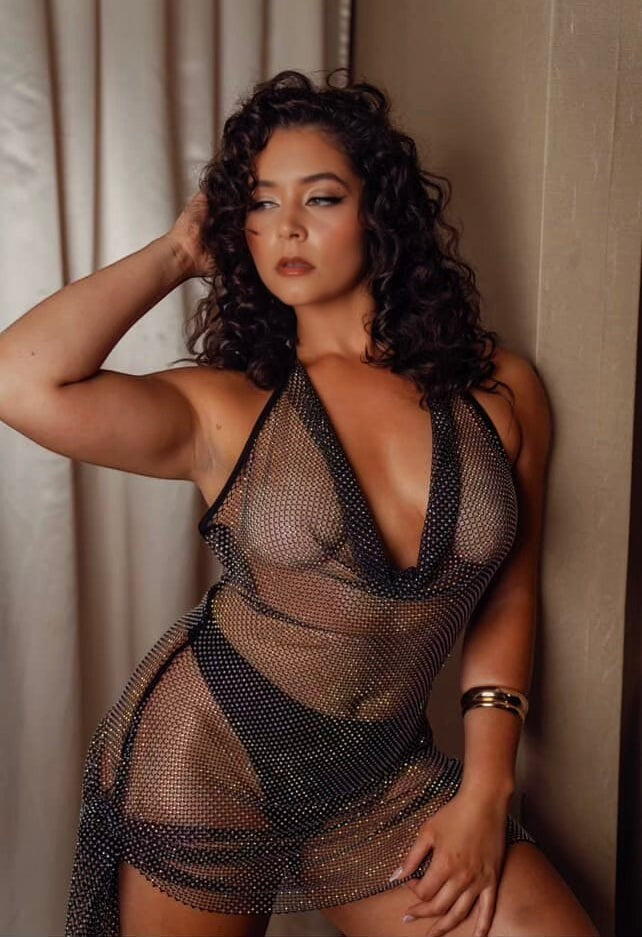 Slay Swimwear black rhinestone fishnet halter dress with a cowl neck, worn as a cover-up.