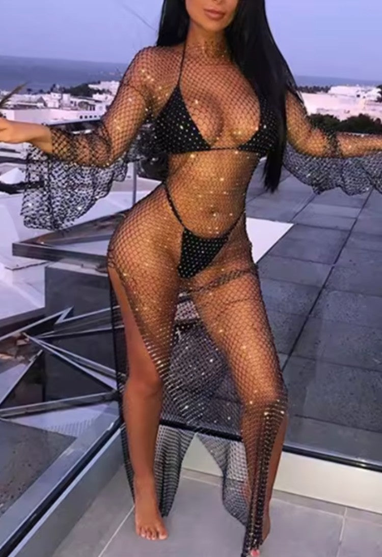 SlaySwimwear black fishnet rhinestone maxi dress cover-up with high neck and bell sleeves, worn over a bikini.