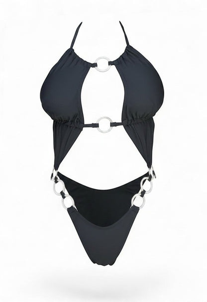 SlaySwimwear black one-piece swimsuit with plunging neckline, strappy details, and silver ring accents on bust, waist, and hips. High-cut leg.