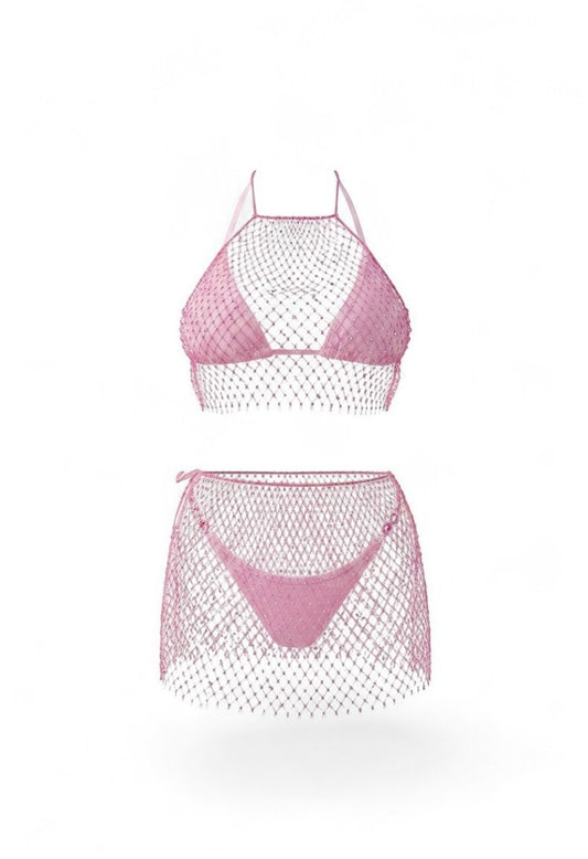SlaySwimwear pink rhinestone fishnet halter top and mini skirt set on a woman at the beach.