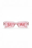 SlaySwimwear translucent pink rectangular statement sunglasses with red "SLAY" text on lenses.