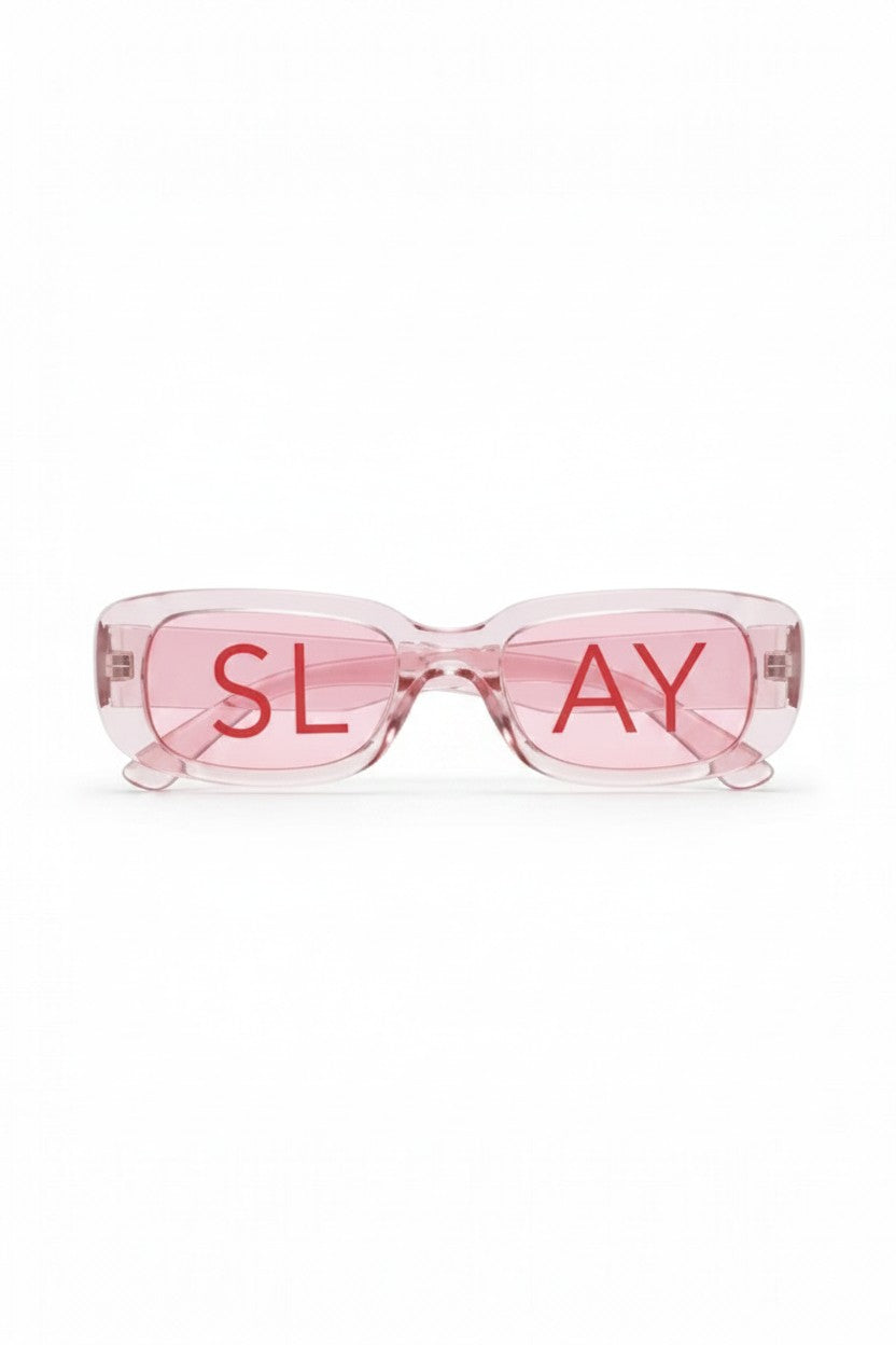 SlaySwimwear translucent pink rectangular statement sunglasses with red "SLAY" text on lenses.