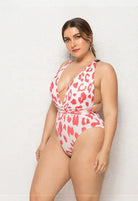 SlaySwimwear KIKI plus size one-piece swimsuit with plunging neckline, halter straps, and cheetah print in white and coral.