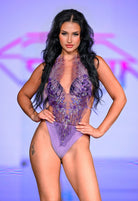 SlaySwimwear purple jeweled one-piece swimsuit with adjustable neck strap and intricate floral beadwork.