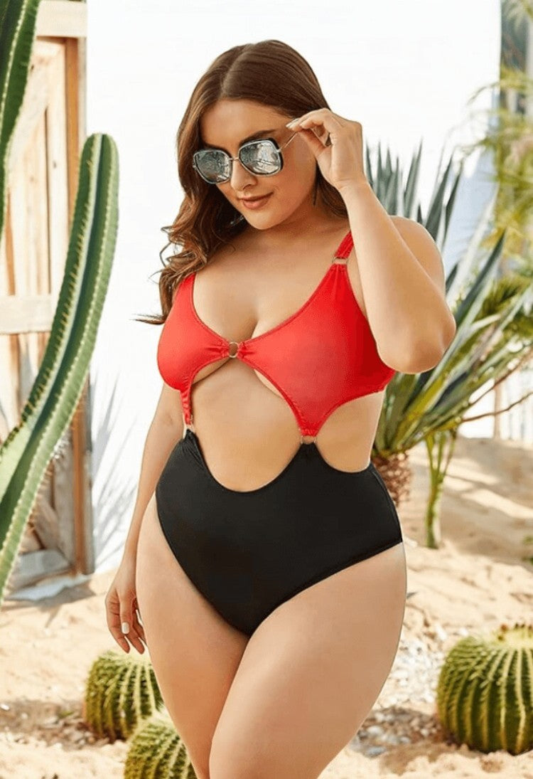 SlaySwimwear Queen Of Hearts red and black color block one-piece swimsuit with cut-outs and gold ring details.