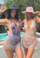 SlaySwimwear women's mini skirt with all-over sparkle, rhinestone clasp closure, and above-the-knee length. Available in purple and pink.