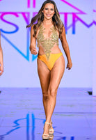 SlaySwimwear model in a yellow one-piece swimsuit with a sheer, gold-embellished bodice. Beachwear.