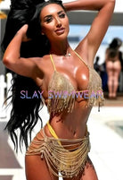 SlaySwimwearHere gold rhinestone bikini set with crystal-style bra top and matching bottoms, featuring fringe and chain details.