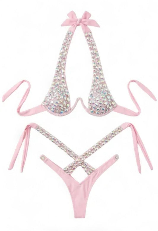 SlaySwimwearHere pink bikini with all-over iridescent rhinestones, halter neck with bow detail, and high-cut cheeky bottoms.